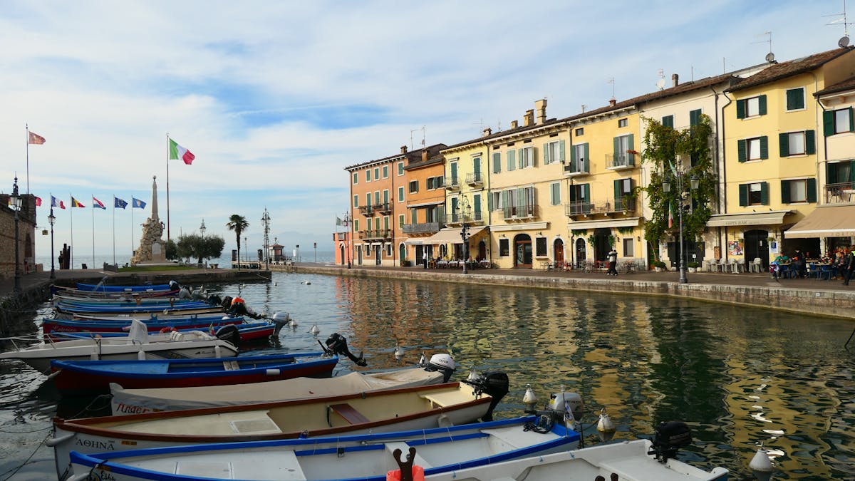 The small stone harbour at Punta San Vigilio with wooden boats and the Locanda restaurant terrace above